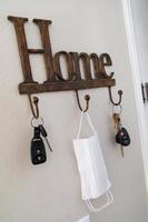 Home Key Hanger Rack Next to Door With Keys and Medical Face Mask During Coronavirus Pandemic. photo