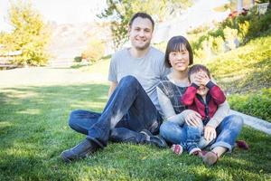 Happy Mixed Race Family Having Fun Outside on the Grass photo