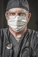 Male Doctor or Nurse Wearing Scrubs, Protective Face Mask and Goggles photo