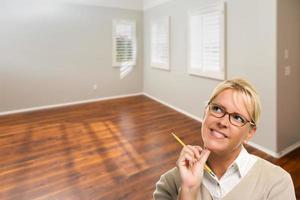 mujer con lápiz en la habitación vacía de la casa nueva foto