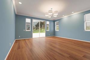 habitación de la casa recién remodelada con pisos de madera acabados, molduras, pintura azul y luces de techo. foto