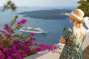 Female Tourist Admiring the View of the Cruise Ship Off the Coast of Santorini Greece. photo