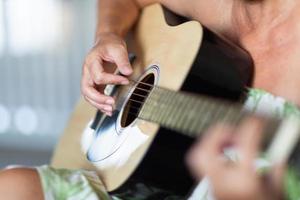 mujer tocando guitarra acústica resumen. foto