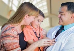 niño de raza mixta, madre y médico divirtiéndose con estetoscopio foto