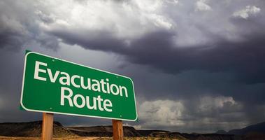 Evacuation Route Green Road Sign and Stormy Clouds photo