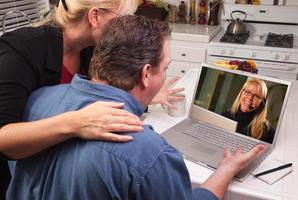pareja en la cocina usando una laptop - atención al cliente foto