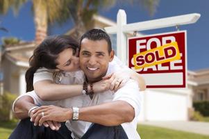 Hispanic Couple, New Home and Sold Real Estate Sign photo