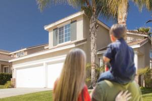 Mixed Race Young Family Looking At Beautiful Home photo