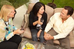 Three Friends Enjoying Wine on the Patio photo