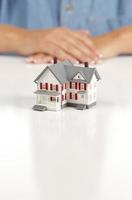 Womans Folded Hands Behind Model House photo