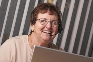 Smiling Senior Adult Woman with Telephone Headset and Monitor photo