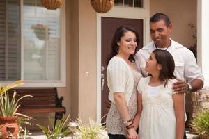 Small Hispanic Family in Front of Their Home photo