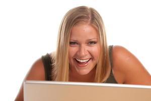 mujer rubia riendo usando laptop aislada en blanco. foto