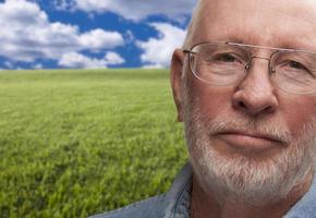 Melancholy Senior Man with Grass Field Behind photo