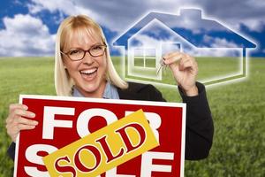 Woman with Sold For Sale Sign, Keys and Ghosted House photo