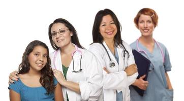 Hispanic Female Doctor with Child Patient and Colleagues Behind photo