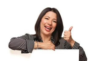 Multiethnic Woman Leaning on Blank White Sign with Thumbs Up photo