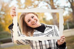 bastante, mujer joven, sonriente, en el parque, con, marco de imagen foto