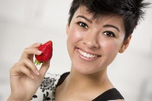 bonita mujer hispana sosteniendo fresa foto