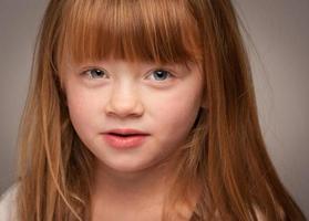 Fun Portrait of an Adorable Red Haired Girl on Grey photo