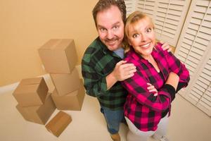 Proud Goofy Couple and Moving Boxes in Empty Room photo