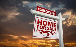 White and Red Foreclosure Home For Sale Real Estate Sign Over Sunset Sky photo