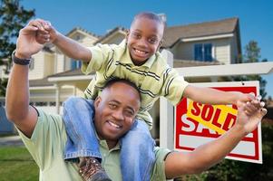 Father and Son In Front of Real Estate Sign and Home photo