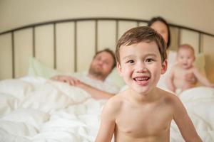 Mixed Race Chinese and Caucasian Boy Laying In Bed with His Family photo