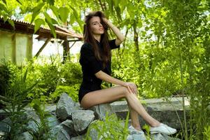 attractive brunette sitting on the rocks in nature photo