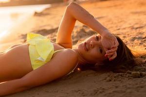 young sexy girl at sunset at the beach photo