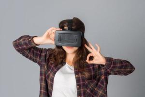 jovencita encantadora en casco de realidad virtual foto