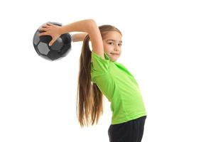 cute little girl standing in the Studio and holds the ball above the head photo