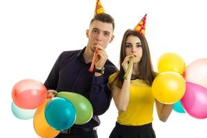 Happy young couple with balloons in hands and horns celebrate birthday party photo