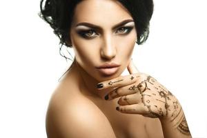 Portrait of fashionable young woman with beautiful makeup looking at you in studio photo