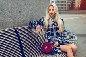 Beautiful young blonde fashion model posing outdoors and looking at the camera photo