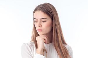 serious thoughtful girl looks down isolated on white background photo