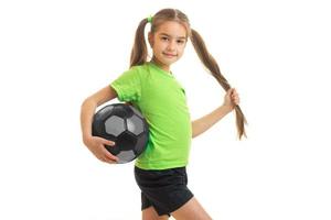 niña linda en camisa verde con balón de fútbol en las manos foto