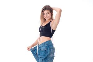 slim girl stands in a large wide jeans lifting arm photo