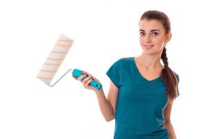 young beautiful brunette woman builder in uniform with paint roller in hands make reovations and posing on camera isolated on white background photo