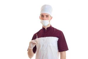 young laboratory doctor in a hat and mask on his face holding a syringe photo