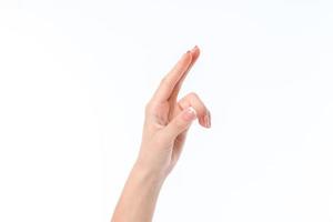 Mano femenina señalando con el dedo hacia arriba aislado sobre fondo blanco. foto