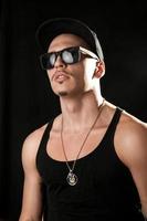 Glamour male model in sunglasses on black background photo