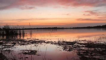 bela vista da natureza ao pôr do sol, vista do céu vermelho-laranja e rio ao pôr do sol. video