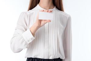 chica en camisa mantiene una hoja de papel de mano aislada sobre fondo blanco foto