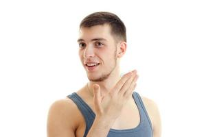 close-up portrait of a young handsome guy who smiles and holds the Palm near the face photo