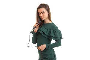 charming lady in the green dress sings in a microphone photo