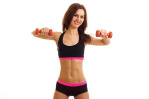 beautiful athletic brunette with a flat belly holding dumbbells and smiling photo