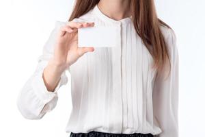 girl in white shirt stands up straight and keeps itself the paper leaf close- photo