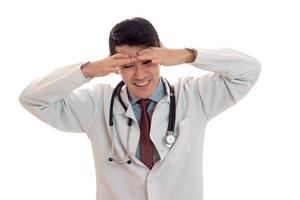 studio portrait of young cheerful male doctor in uniform posing isolated on white background photo