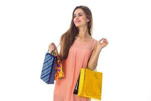 young girl stands with gifts in hands looks away and smiling isolated on white background photo